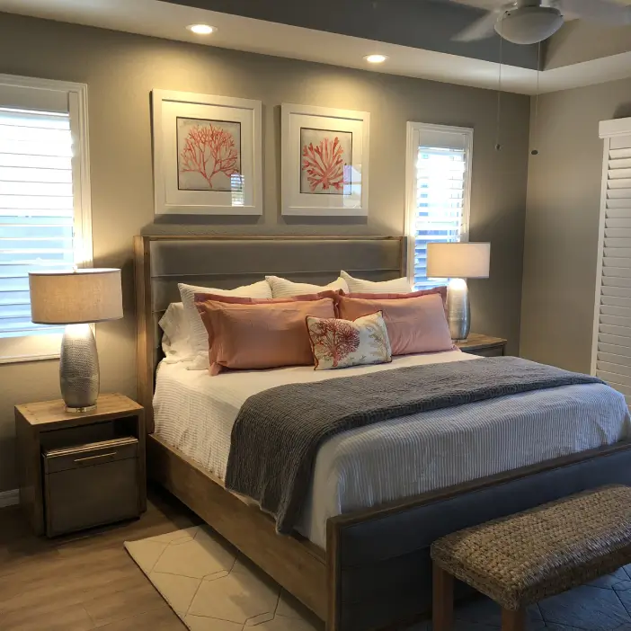 Coastal transitional bedroom interior design in Fort Myers featuring layered bedding, warm wood tones, and coral-inspired artwork
